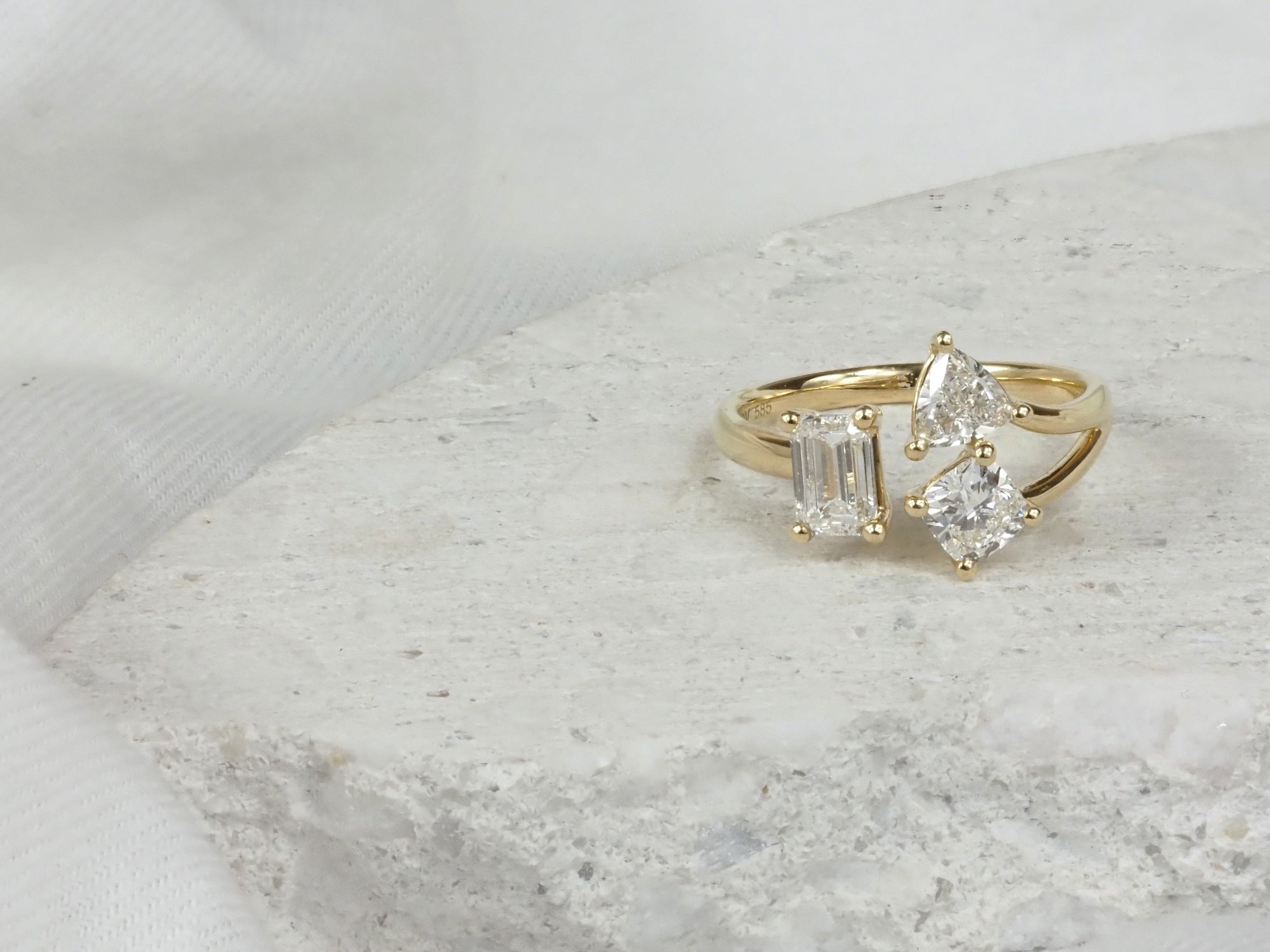 Gold ring with diamond accents on a marble surface