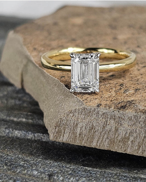 Gold ring with a diamond on a stone surface